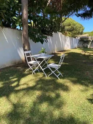two chairs and a table and a tree in a yard at Villa Verde con Piscina a 800m de la Playa by Chiclana Dreams in Chiclana de la Frontera