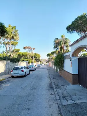 a street with cars parked on the side of the road at Villa Verde con Piscina a 800m de la Playa by Chiclana Dreams in Chiclana de la Frontera