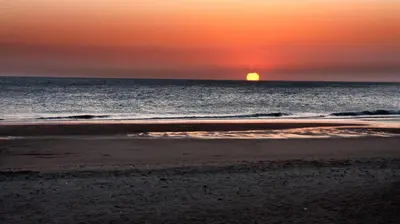 a sunset on the beach with the sun in the ocean at Villa Verde con Piscina a 800m de la Playa by Chiclana Dreams in Chiclana de la Frontera