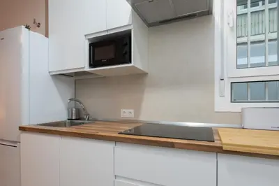 a white kitchen with a sink and a microwave at Aire del Sur Cádiz in Cádiz