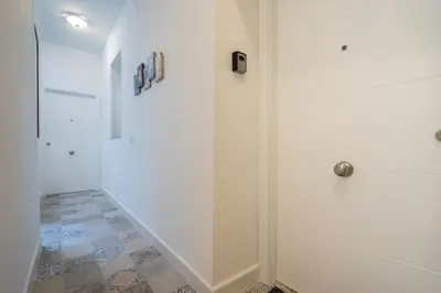 a white hallway with a shower and a door at Aire del Sur Cádiz in Cádiz