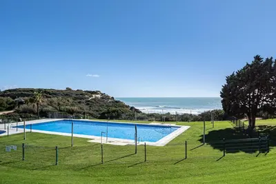 a swimming pool with the ocean in the background at Ocean beachside house with pool 46 in Conil de la Frontera
