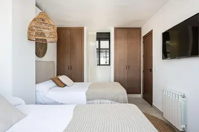 a bedroom with two beds and a flat screen tv at Ocean beachside house with pool 46 in Conil de la Frontera