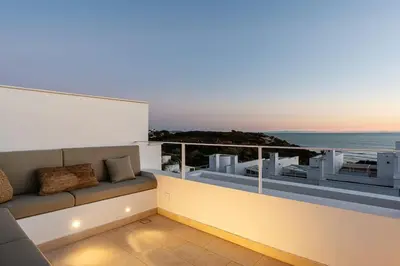 a balcony with a couch and a view of the ocean at Ocean beachside house with pool 46 in Conil de la Frontera