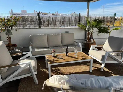 a patio with a couch and chairs and a table at La Terraza de Porvenir 10 - Jerez de la Frontera in Jerez de la Frontera