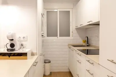 a white kitchen with white cabinets and a sink at Zurbarán by Gades Gestión in Cádiz