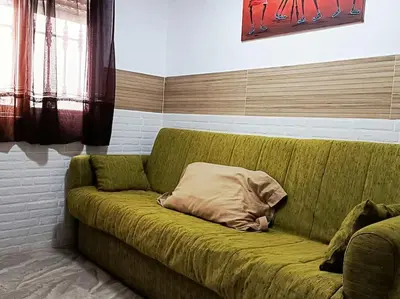 a green couch with a pillow on it in a room at casa familiar in San Fernando