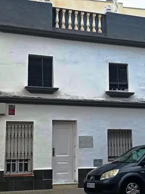a white building with two windows and a door at casa familiar in San Fernando