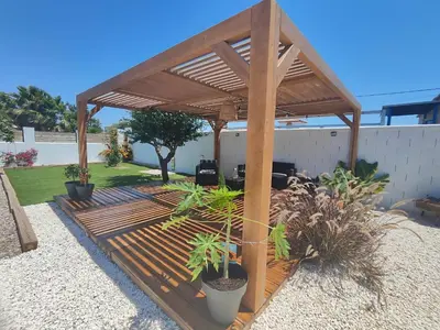 a wooden pergola with plants in a yard at TITO MIGUEL VILLAGE in Chiclana de la Frontera