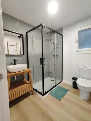 a bathroom with a glass shower and a toilet at TITO MIGUEL VILLAGE in Chiclana de la Frontera