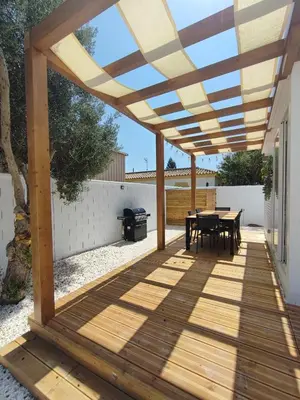 a pergola over a patio with a table and a grill at TITO MIGUEL VILLAGE in Chiclana de la Frontera