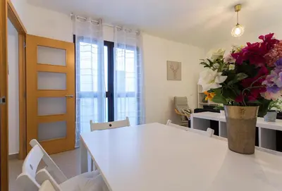 a white table with chairs and a vase of flowers at Cruz Vieja Centrico 3 Rooms in Jerez de la Frontera