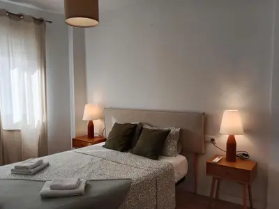 a bedroom with a bed with two lamps and two tables at Dúplex Apartment Sol de la Plazuela in Jerez de la Frontera