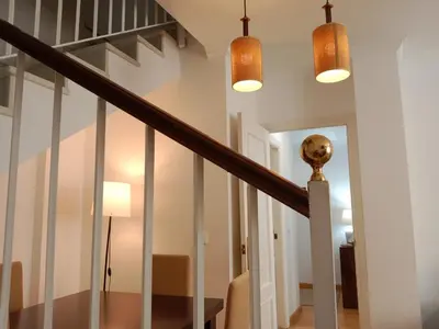 a staircase in a home with white walls and wooden floors at Dúplex Apartment Sol de la Plazuela in Jerez de la Frontera