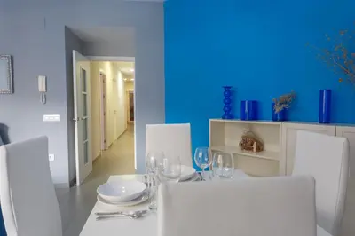 a dining room with a white table and white chairs at PUERTA del MAR Family Home by Cadiz4Rentals in Cádiz