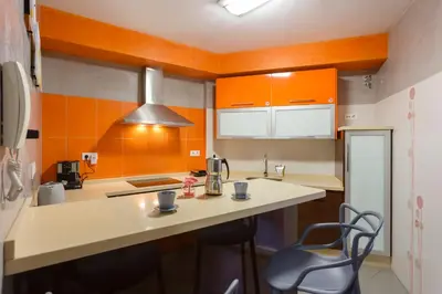 a kitchen with orange and white cabinets and a counter at PUERTA del MAR Family Home by Cadiz4Rentals in Cádiz