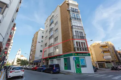a tall building on a city street with parked cars at PUERTA del MAR Family Home by Cadiz4Rentals in Cádiz