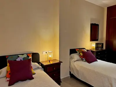 a hotel room with two beds and a night stand at Apartamento Larga 65 - Ole Solutions in Jerez de la Frontera