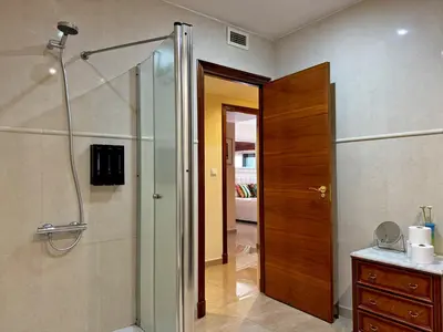 a bathroom with a shower and a wooden door at Apartamento Larga 65 - Ole Solutions in Jerez de la Frontera