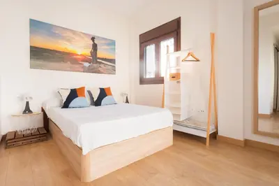 a bedroom with a white bed and a painting on the wall at VILLA DE LUJO CLIMATIZADA. PISCINA Y JARDIN PRIVADO in Chiclana de la Frontera
