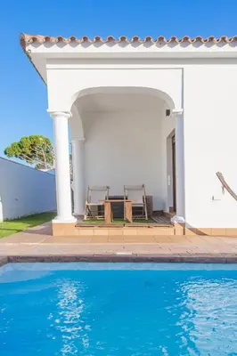 a villa with a swimming pool and a house at VILLA DE LUJO CLIMATIZADA. PISCINA Y JARDIN PRIVADO in Chiclana de la Frontera