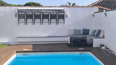 a patio with a couch next to a swimming pool at VILLA DE LUJO CLIMATIZADA. PISCINA Y JARDIN PRIVADO in Chiclana de la Frontera