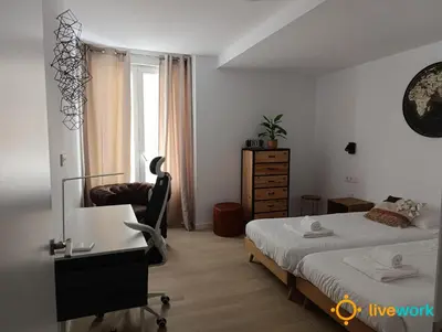 a bedroom with a bed and a desk and a chair at Travelers Dream by LiveWork in Cádiz