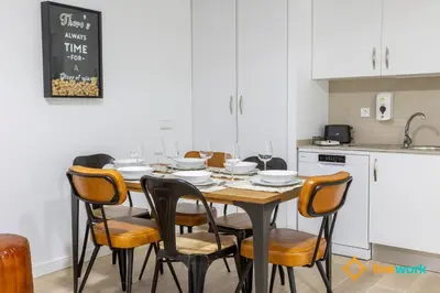 a kitchen with a table with chairs and wine glasses at Travelers Dream by LiveWork in Cádiz