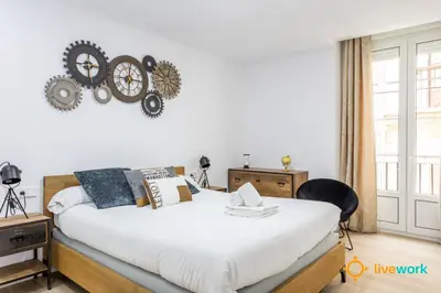 a bedroom with a bed and a clock on the wall at Travelers Dream by LiveWork in Cádiz