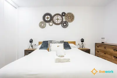 a bedroom with a white bed with gears on the wall at Travelers Dream by LiveWork in Cádiz