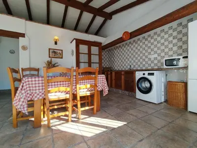 a dining room with a table and a washing machine at Hacienda los Majadales in Conil de la Frontera