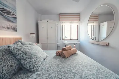 a stuffed animal sitting on a bed in a bedroom at Baylight Retreat Apartment in El Puerto de Santa María