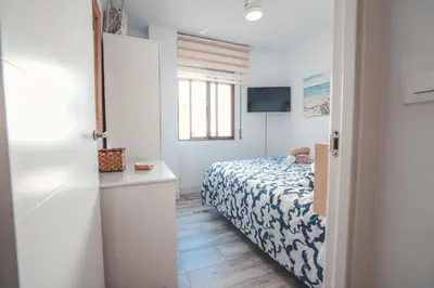 a small bedroom with a bed and a television at Baylight Retreat Apartment in El Puerto de Santa María