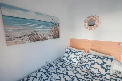 a bedroom with a bed and a picture on the wall at Baylight Retreat Apartment in El Puerto de Santa María
