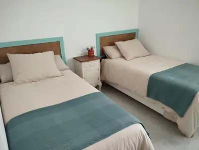 two beds sitting next to each other in a bedroom at LA PONDEROSA BEACH in Sanlúcar de Barrameda