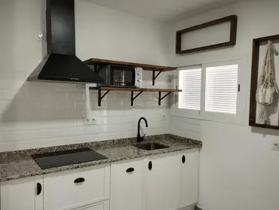 a white kitchen with a sink and a microwave at LA PONDEROSA BEACH in Sanlúcar de Barrameda