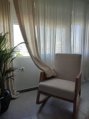a chair sitting in a room with a window at LA PONDEROSA BEACH in Sanlúcar de Barrameda