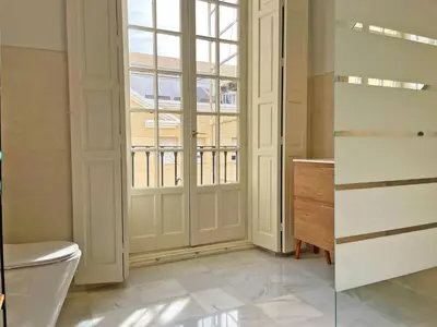a bathroom with a toilet and a window at Apartamento Villamarta - Ole Solutions in Jerez de la Frontera