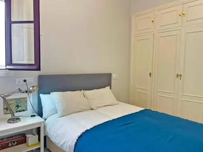 a bedroom with a bed with blue and white at Apartamento Villamarta - Ole Solutions in Jerez de la Frontera