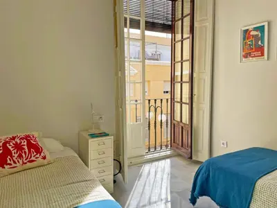 a bedroom with a bed and a door to a balcony at Apartamento Villamarta - Ole Solutions in Jerez de la Frontera