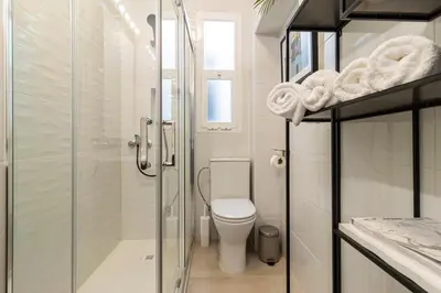 a bathroom with a toilet and a glass shower at El Balcón de la Bodega - Luxurious apartment in Jerez with gym in Jerez de la Frontera