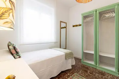 a bedroom with two beds and a window at El Balcón de la Bodega - Luxurious apartment in Jerez with gym in Jerez de la Frontera