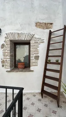 a brick wall with a window and a staircase at Apartamentos Jerez Siglo XIX in Jerez de la Frontera