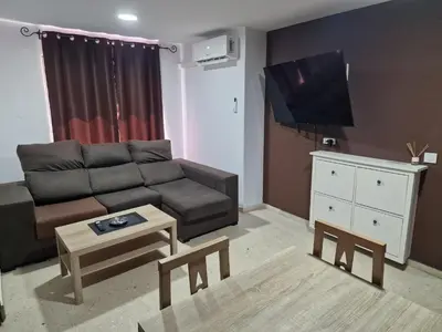 a living room with a couch and a tv at Piso las marismas in Chiclana de la Frontera
