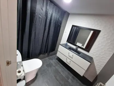 a bathroom with a toilet and a television on the wall at Piso las marismas in Chiclana de la Frontera