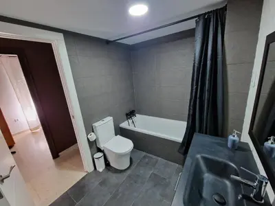 a bathroom with a toilet and a tub and a sink at Piso las marismas in Chiclana de la Frontera
