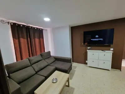 a living room with a couch and a flat screen tv at Piso las marismas in Chiclana de la Frontera