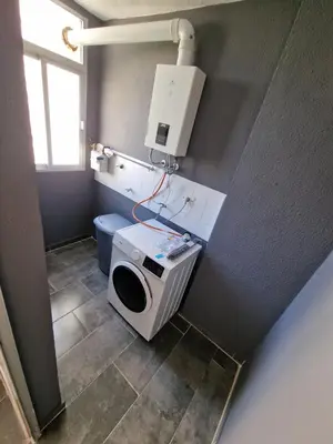 a bathroom with a washing machine and a toilet at Piso las marismas in Chiclana de la Frontera