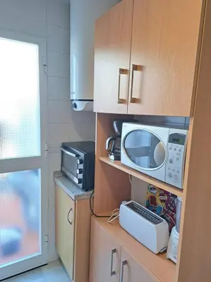 a kitchen with a microwave and a toaster oven at Dúplex 4, primera línea de Playa in Sanlúcar de Barrameda