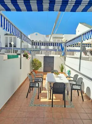 a patio with a table and chairs on a balcony at Dúplex 4, primera línea de Playa in Sanlúcar de Barrameda